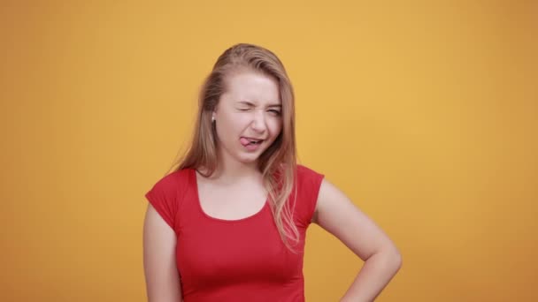 jovem loira menina em vermelho t-shirt sobre isolado laranja fundo mostra emoções
 - Filmagem, Vídeo