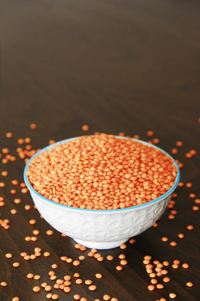 oranžově suché malé orientální čočkové krupice v keramickém bílém plechu - Fotografie, Obrázek