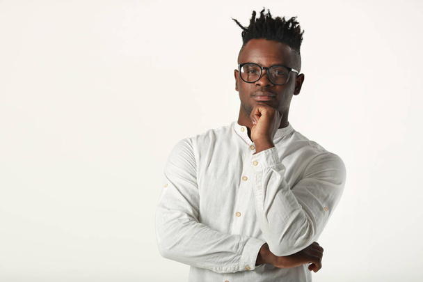 handsome young african man in glasses and white shirt on a white background - 写真・画像