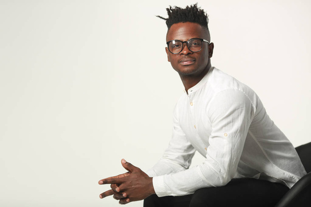 handsome young african man in glasses and white shirt on a white background - Фото, зображення