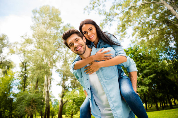 Low angle view photo of cute pair rejoicing together walking summer green park outdoors wear denim outfit - Foto, Bild
