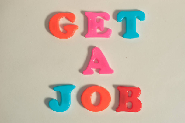 plastic letters bericht krijg een baan op witte geïsoleerde achtergrond - Foto, afbeelding