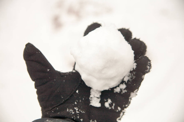 πραγματικές χιονόμπαλες με τα χέρια τους τυλιγμένα από το φρέσκο χιόνι το χειμώνα στο δρόμο - Φωτογραφία, εικόνα