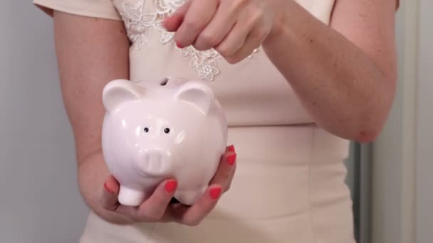 Mulher segurando banco porquinho e moedas
 - Filmagem, Vídeo