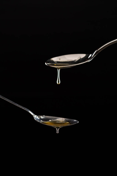 χρυσό γλυκό μέλι στάζει από το κουτάλι  - Φωτογραφία, εικόνα