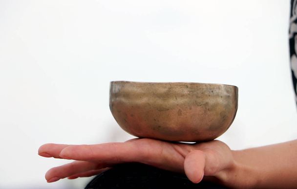 Музичний інструмент-спів гімалайського чаші. Співаючий дзвін тримає дівчинку в руці. Практика лікування вібрацій, Сурья, йоги, медитації - Фото, зображення