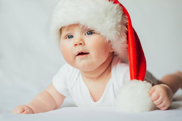 Porträt eines kleinen Babys mit Weihnachtsmütze auf weißem Hintergrund - Foto, Bild