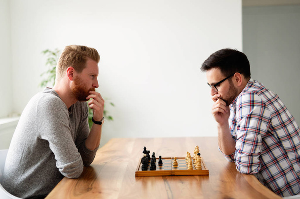 Portrait of two young man playing intelligent game of chess - Foto, Imagem