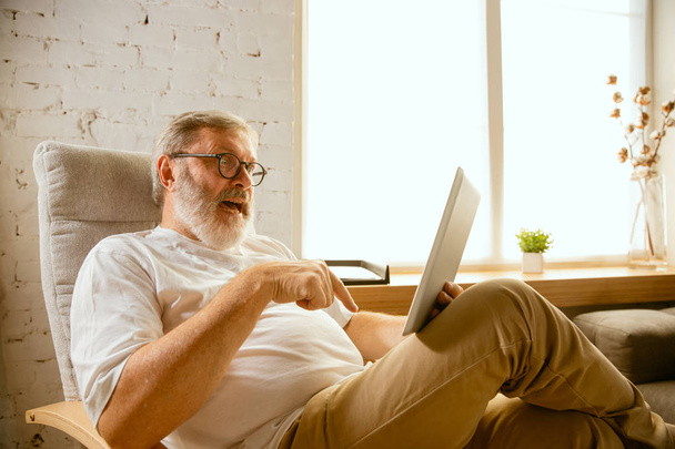 Senior man working with tablet at home - concept of home studying - 写真・画像