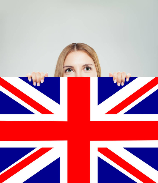 イギリスの国旗を背景にした幸せな少女の肖像画。若い女性 - 写真・画像