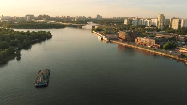 Panoramablick auf den Flusshafen mit im Wasser verankerten Flottenkähnen am Ufer. Landschaft mit großem welligem Fluss - Filmmaterial, Video