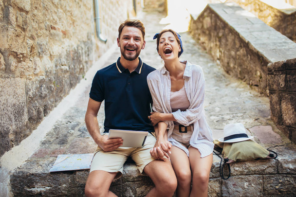 Merdivenlerde dijital tablet kullanan romantik turist çifti. - Fotoğraf, Görsel