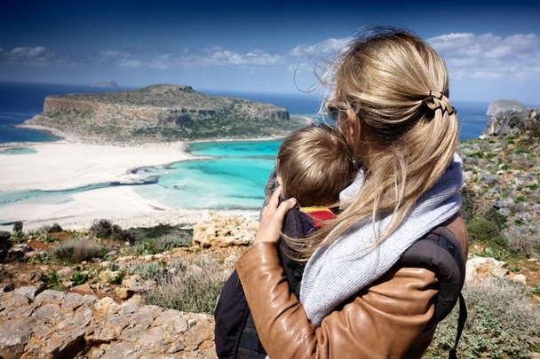 Madre llevando hijo en portador y mirando al mar
 - Foto, imagen