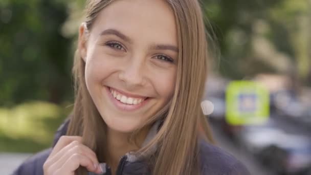 Close-up of attractive young caucasian woman with long brown hair smiling happily looking at camera. Emotions, happiness, good mood. - Záběry, video