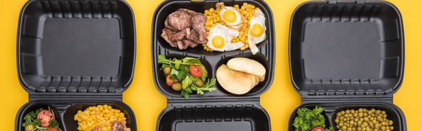 zöldségeket, almát, húst, tükörtojást és sárgán izolált salátákat tartalmazó ökocsomagok panorámaképe     - Fotó, kép