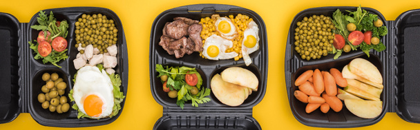 panoramic shot of eco packages with vegetables, apples, meat, fried eggs and salads isolated on yellow     - Photo, Image