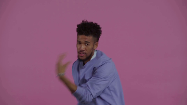 glücklich afrikanisch-amerikanischer Mann tanzt isoliert auf lila  - Filmmaterial, Video