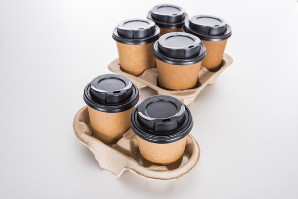 паперові стаканчики з кавою в картонному лотку на білому фоні
  - Фото, зображення