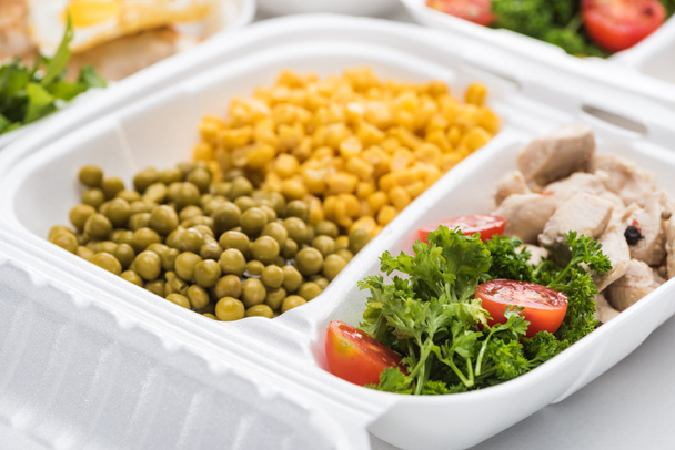 enfoque selectivo del paquete ecológico con verduras, carne y ensaladas sobre fondo blanco
  - Foto, imagen