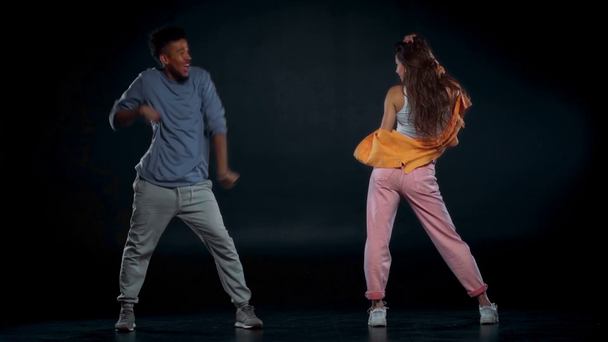 Χαρούμενος Αφροαμερικάνος άντρας και γυναίκα χορεύουν στα μαύρα  - Πλάνα, βίντεο