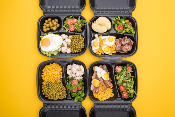 vista superior de los paquetes ecológicos con manzanas, verduras, carne, huevos fritos y ensaladas aisladas en amarillo
  - Foto, imagen