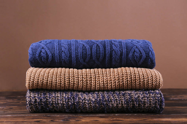 Pile of knitted sweaters of different colors and patterns perfectly stacked. - Foto, afbeelding