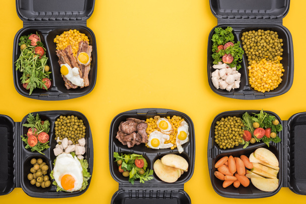 Elma, sebze, et, sahanda yumurta ve salata içeren ekolojik paketlerin üst görüntüsü sarı üzerine izole edilmiş.  - Fotoğraf, Görsel