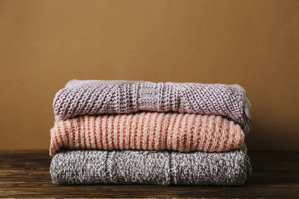 Pile of knitted sweaters of different colors and patterns perfectly stacked. - Foto, imagen