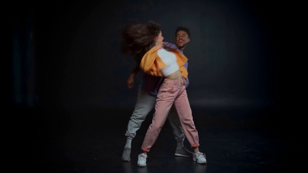 felice uomo africano americano e donna alla moda che balla sul nero
  - Filmati, video