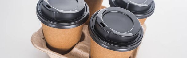 panoramic shot of paper cups with coffee in cardboard tray on white background  - Φωτογραφία, εικόνα