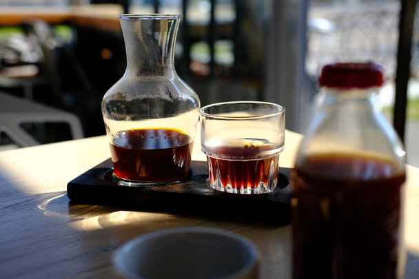 jug and glass of fresh cold brewed black coffee on cafe table - Fotoğraf, Görsel