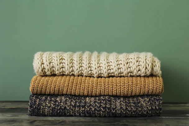 Pile of knitted sweaters of different colors and patterns perfectly stacked. - Photo, Image