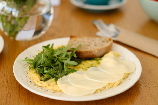 served scrambled eggs with arugula and cheese for breakfast in coffee shop - Foto, immagini