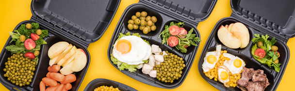 panoramic shot of eco packages with vegetables, apples, meat, fried eggs and salads isolated on yellow     - Photo, Image
