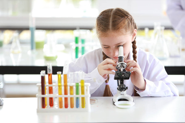 boldog kis kaukázusi lány hogy a tudományos kísérletek a Mikroszkóp (oktatás és tudós koncepció) - Fotó, kép