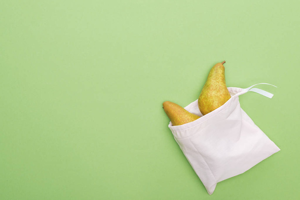 top view of pears in eco friendly white bag isolated on green - Foto, Imagem