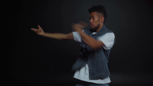 stylische afrikanisch-amerikanische Mann tanzen auf schwarz  - Filmmaterial, Video