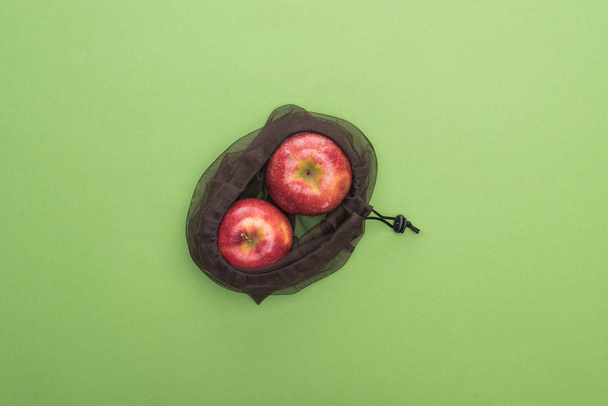 top view of red ripe apples in eco friendly bag isolated on green - Foto, immagini