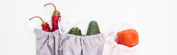 top view of fresh avocados, tomatoes and chili peppers in eco friendly bags isolated on white, panoramic shot - Φωτογραφία, εικόνα