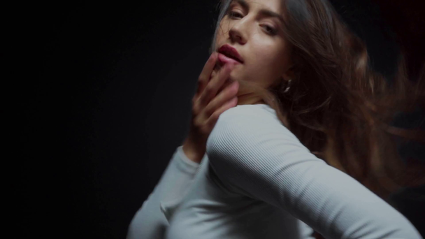 Fokuszug der Frau, die Haare berührt und auf Schwarz tanzt  - Filmmaterial, Video
