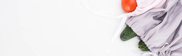 Κορυφαία όψη των φρέσκων αβοκάντο και τομάτας σε φιλικές προς το φιλικό προς το μέρος τσάντες, απομονωμένες σε λευκό, πανοραμικό πλάνο - Φωτογραφία, εικόνα