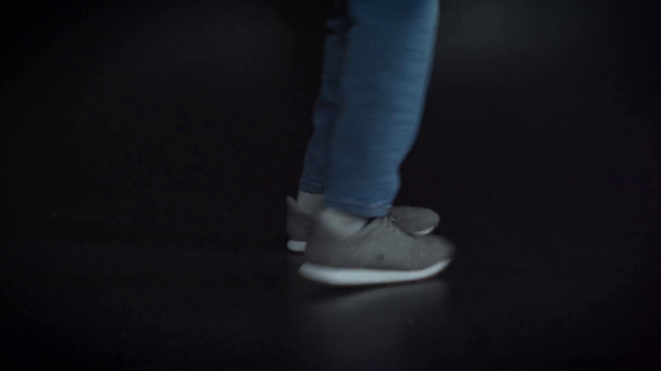 cropped view of man in sneakers dancing on black  - Materiał filmowy, wideo