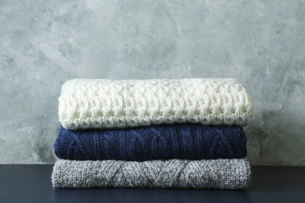 Pile of knitted sweaters of different colors and patterns perfectly stacked. - Photo, Image