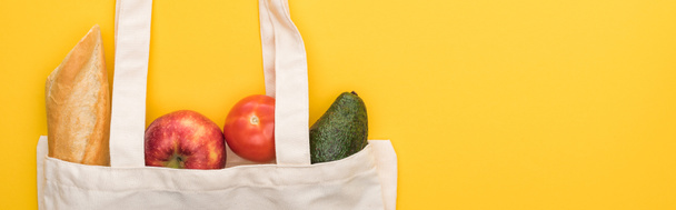 top view of ripe apples, baguette and avocado in eco friendly bags isolated on yellow, panoramic shot - Fotografie, Obrázek