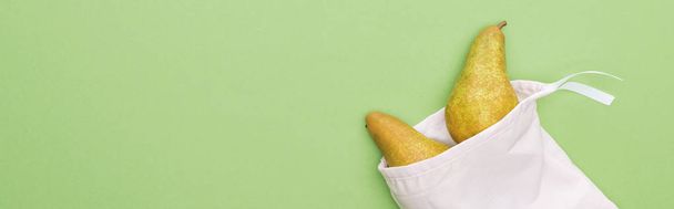 緑、パノラマショットに隔離された環境に優しい白いバッグの梨のトップビュー - 写真・画像