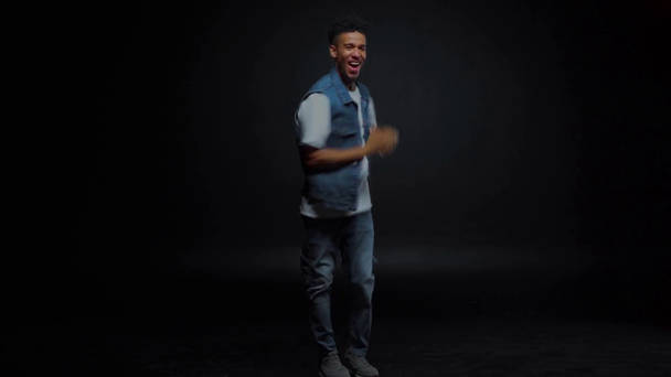 stylový africký Američan v džínách tanec na černé  - Záběry, video