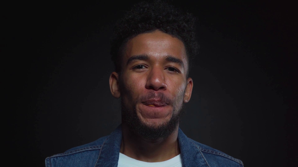 gelukkig afrikaanse amerikaanse man blazen bubble gum op zwart  - Video