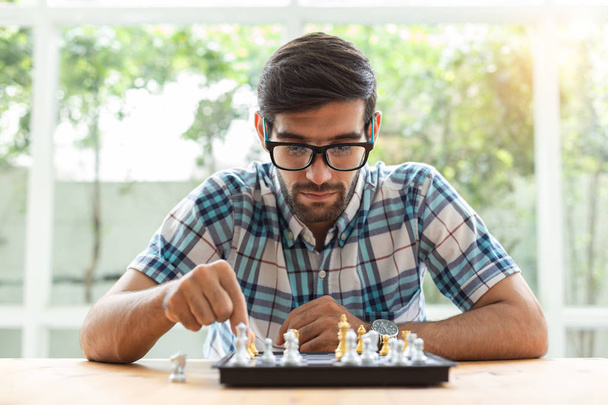 Young man sitting in playing chess at home. - Valokuva, kuva