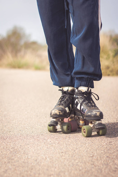Nahaufnahme der Beine eines Skaters und seiner gebrauchten Schlittschuhe - Foto, Bild
