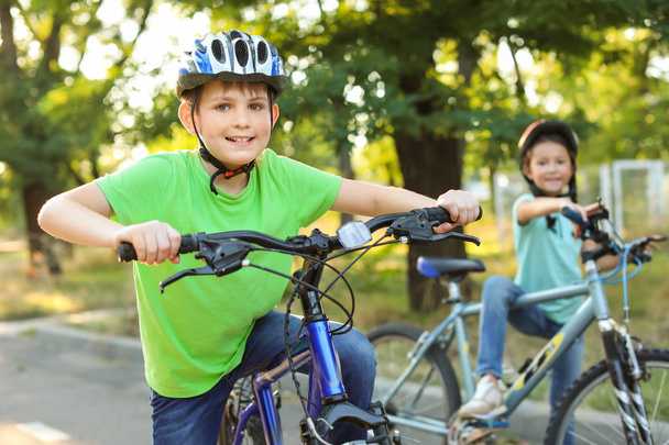 Cute children riding bicycles outdoors - Fotó, kép
